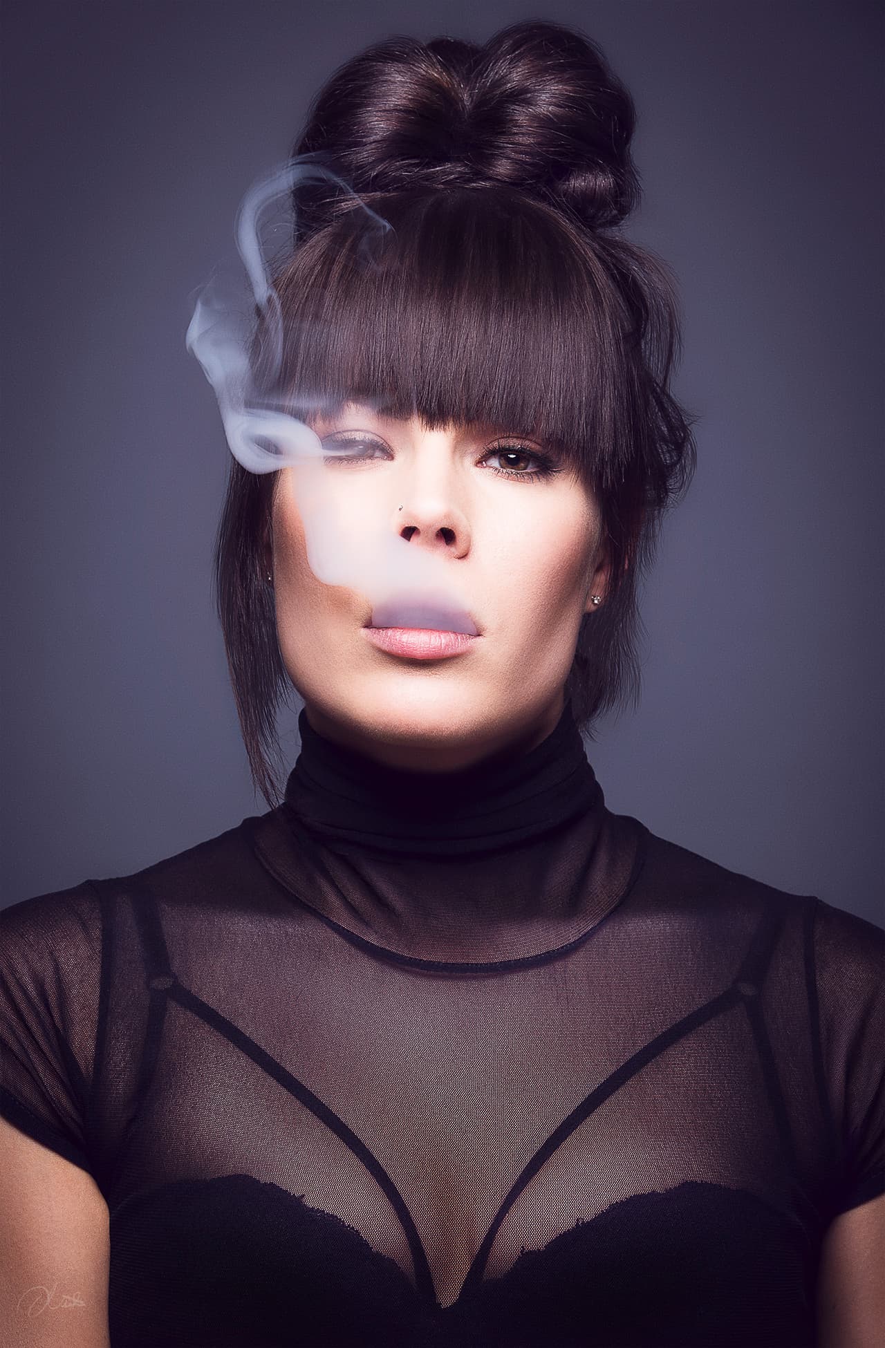 A portrait of a woman exhaling vapor